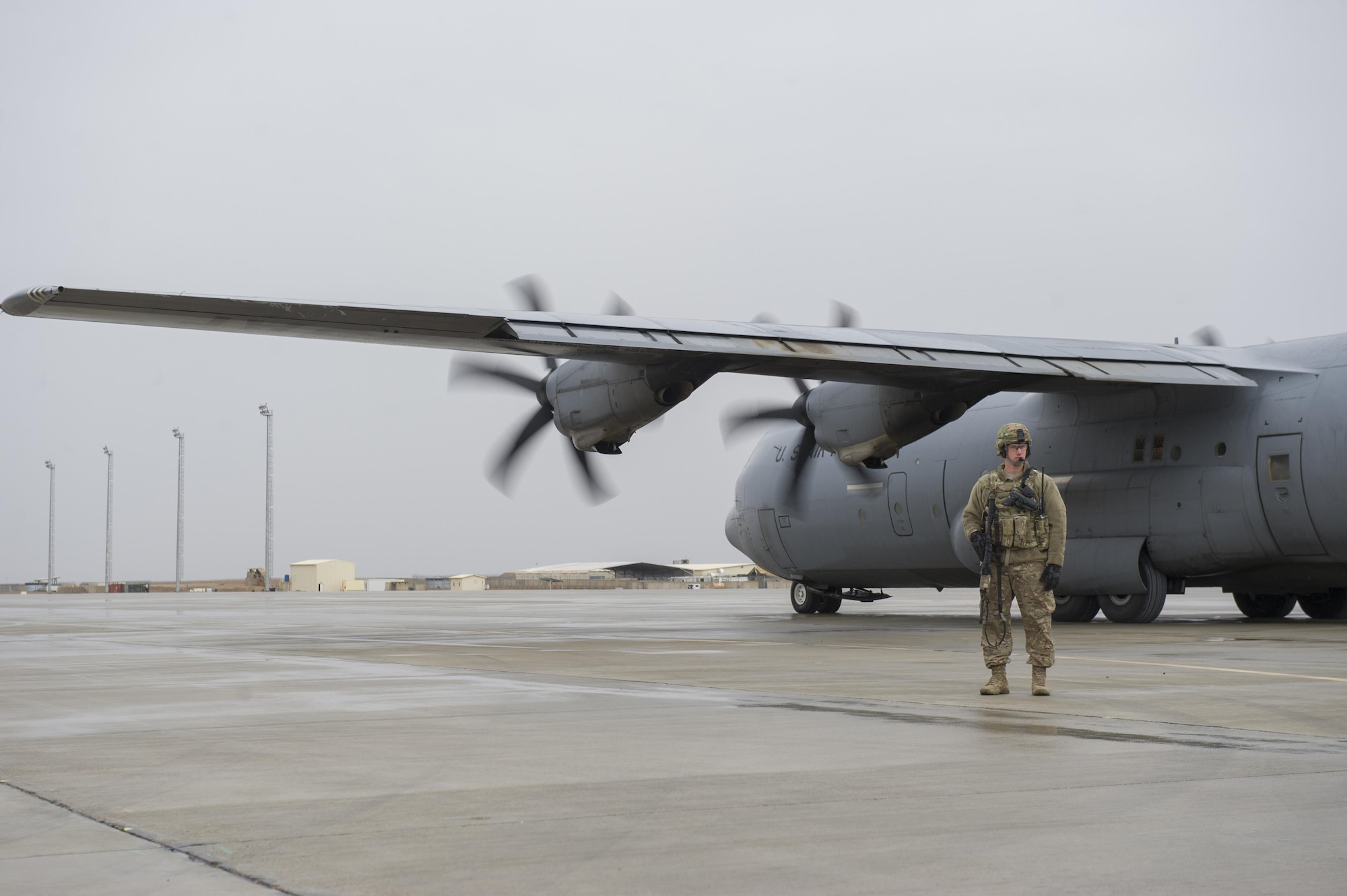 Staff Sgt. Tyler Berogan, a 455th Expeditionary Security Forces Squadron Fly Away Security Team member, provides security as a C-130J Super Hercules is unloaded at Camp Bastion, Afghanistan, Jan. 3, 2016. The 455th ESFS FAST is the all-encompassing security team that provides ground safety and cockpit denial to protect the aircraft and crew. (U.S. Air Force photo/Tech. Sgt. Robert Cloys)