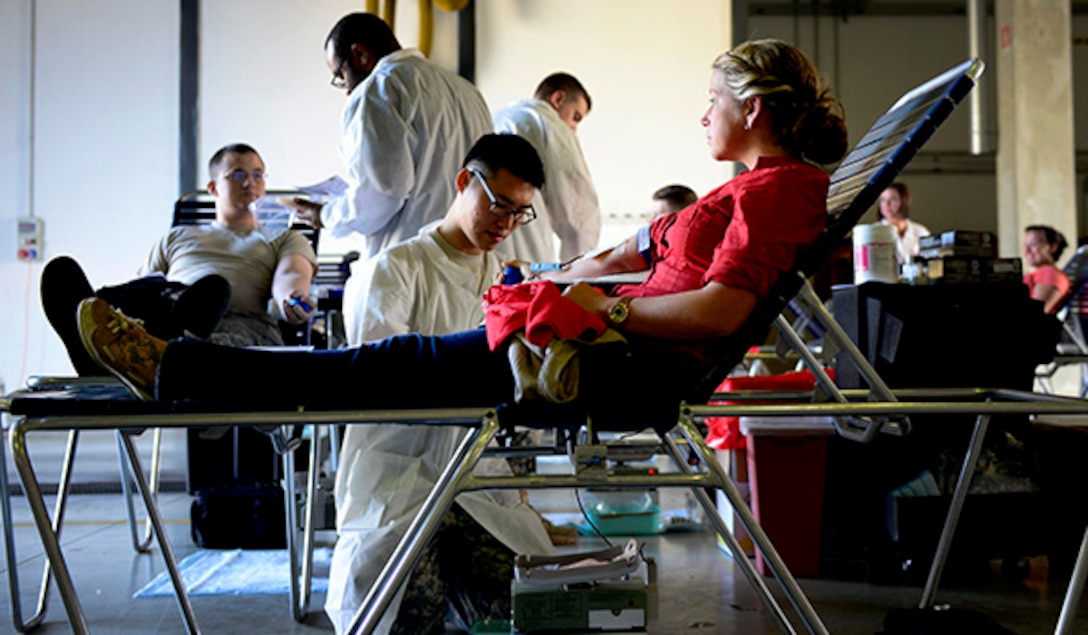 U.S. Army Spc. Hayeon McCurley, Landstuhl Regional Medical Center medical laboratory technician, prepares U.S. Air Force Senior Airman Kimberly Gray, 31st Security Forces Squadron investigator, to give blood during the Armed Services Blood Program blood drive, Nov. 9, 2015, at Aviano Air Base, Italy. ASBP blood drives allow members the opportunity to donate blood for service members and their families. U.S. Air Force photo by Senior Airman Areca T. Bell/Released