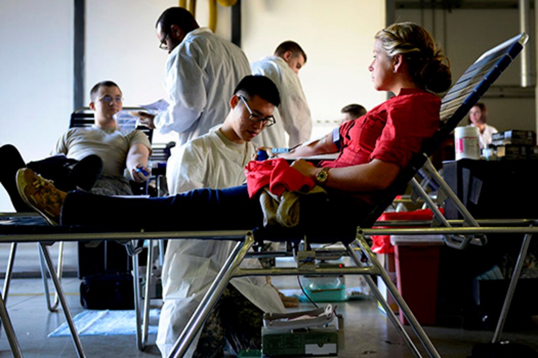 U.S. Army Spc. Hayeon McCurley, Landstuhl Regional Medical Center medical laboratory technician, prepares U.S. Air Force Senior Airman Kimberly Gray, 31st Security Forces Squadron investigator, to give blood during the Armed Services Blood Program blood drive, Nov. 9, 2015, at Aviano Air Base, Italy. ASBP blood drives allow members the opportunity to donate blood for service members and their families. U.S. Air Force photo by Senior Airman Areca T. Bell/Released