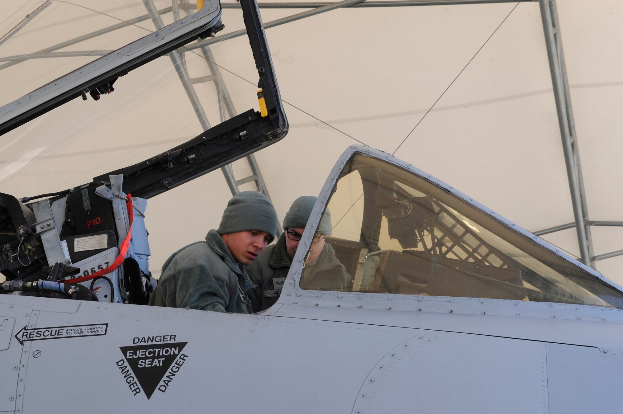 U.S. Air Force Airman 1st Class Chris Renfroe, 74th Aircraft Maintenance Unit crew chief, left, and Senior Airman Tyler Hester, 476th Maintenance Squadron crew chief, prepare an A-10C Thunderbolt II cockpit prior to a flight, Jan. 5, 2016, at Moody Air Force Base, Ga. When performing aircraft launches, crew chiefs prepare aircraft and their pilots for flight. (U.S. Air Force photo by Airman 1st Class Kathleen D. Bryant/Released)
