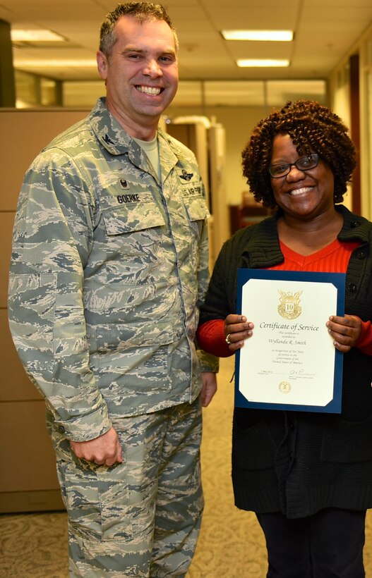 Col. Karl Goerke, outgoing 932nd Airlift Wing commander, presents a very special ten year certificate and pin to Wyllanda Smith, financial management office, with the certificate recognizing her amazing and challenging 10 years of civil service contribution to the United States government. (U.S. Air Force photo by Christopher Parr)

