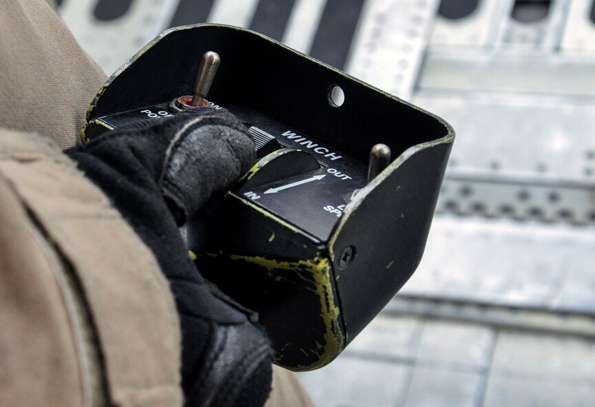Airman 1st Class Anthony Green, 9th Airlift Squadron, Dover Air Force Base, Del., operates a winch during the unloading of a helicopter from a C-5M Super Galaxy at Bagram Air Field, Afghanistan, Dec. 26, 2015. The C-5M is the largest military transport aircraft in the world, capable of hauling 270,000 pounds of cargo. (U.S. Air Force photo by Tech. Sgt. Nicholas Rau)