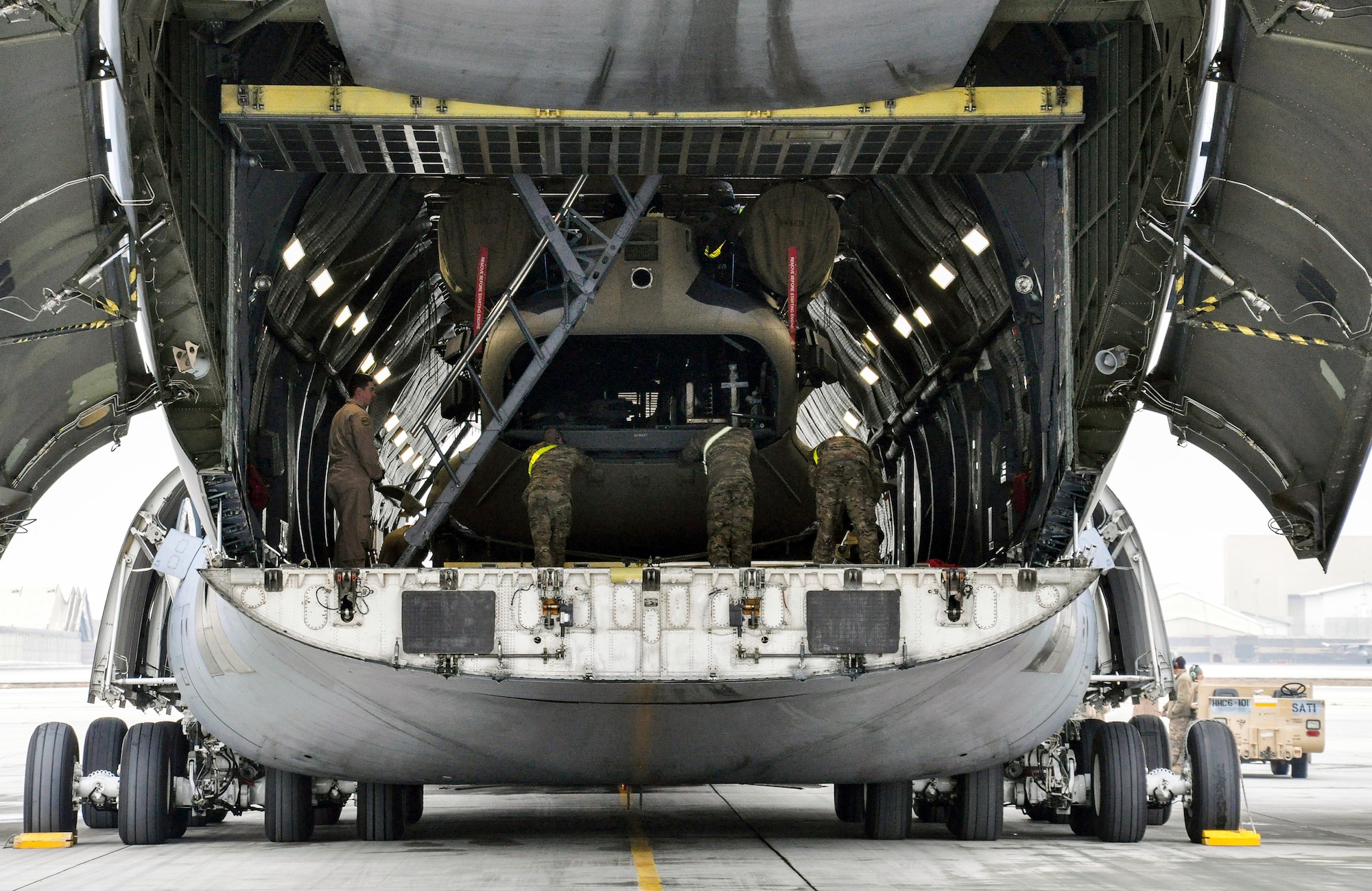 Soldiers from Task Force Destiny pair with Airmen from 9th Airlift Squadron, Dover Air Force Base, Del., to unload a helicopter from a C-5M Super Galaxy at Bagram Air Field, Afghanistan, Dec. 26, 2015. The C-5M is the largest military transport aircraft in the world, capable of hauling 270,000 pounds of cargo. (U.S. Air Force photo by Tech. Sgt. Nicholas Rau)