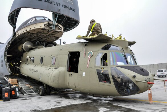 Soldiers from Task Force Destiny pair with Airmen from 9th Airlift Squadron, Dover Air Force Base, Del., to unload a helicopter from a C-5M Super Galaxy at Bagram Air Field, Afghanistan, Dec. 26, 2015. The C-5M is the largest military transport aircraft in the world, capable of hauling 270,000 pounds of cargo. (U.S. Air Force photo by Tech. Sgt. Nicholas Rau)