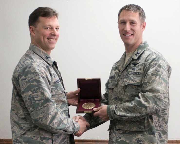 Col. Dagvin Anderson, 58th Special Operations Wing commander, presents the Cheney Award to Capt. Erik Greendyke, 36th Rescue Squadron aircraft commander, Dec. 18, 2015, at Fairchild Air Force Base, Wash. The Cheney Award honors an Air Force member for an act of valor, extreme fortitude or self-sacrifice in a humanitarian interest, performed in connection with aircraft, but not necessarily of a military nature. (Courtesy Photo)