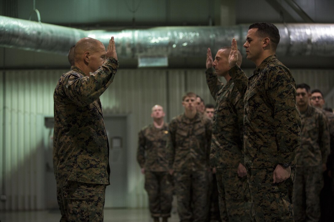 General Robert B. Neller, Commandant of the Marine Corps, reenlists two Marines with the Black Sea Rotational Force during his visit at Mihail Kogalniceanu Air Base, Romania, Dec. 25, 2015. General Neller and Sgt. Maj. Ronald L. Green, Sergeant Major of the Marine Corps, visited the base and engaged the Marines and offer them the opportunity to ask questions. (U.S. Marine Corps photo by Lance Cpl. Melanye E. Martinez/Released)