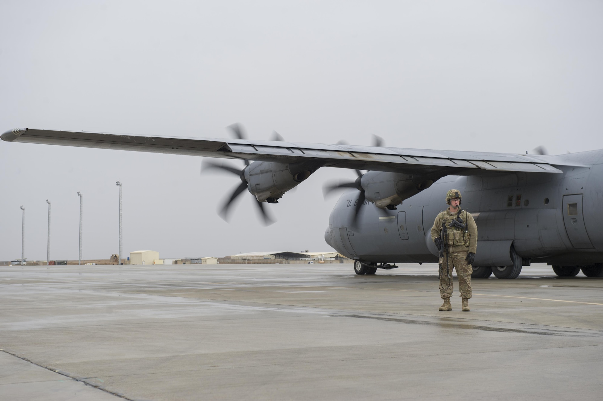 Staff Sgt. Tyler Berogan, 455th Expeditionary Security Forces Squadron Fly Away Security Team memeber, provides security as a C-130J Super Hercules is unloaded at Camp Bastion, Afghanistan Jan. 3, 2016. The 455th ESFS FAST is the all-encompassing security team that provides ground safety and cockpit denial to protect the aircraft and crew. (U.S. Air Force photo/Tech. Sgt. Robert Cloys)