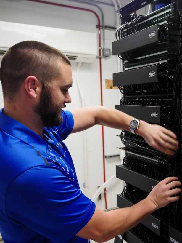 Chris Kish, technician, inspects a communications closet at the Defense Information School on Fort Meade, Md., Jan. 7, 2016. The IT team led the effort to plan and execute the successful running of 236.2 miles of cable, installation of 1,978 data drops and 450 phone drops, and the transfer of 2,400 computer systems from south campus to the main campus to prepare for training in the new wing.