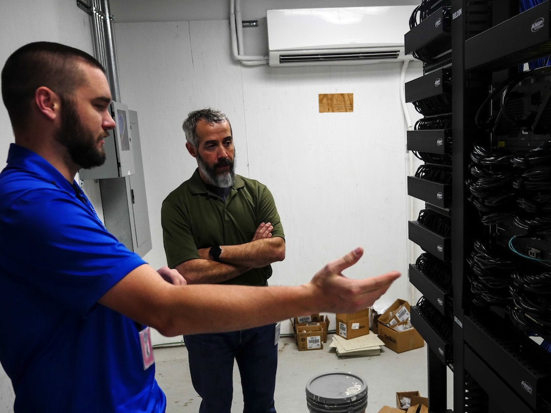 Chris Kish, technician, discusses port availability in a communications closet with Rob Phelps, Defense Information School information technology operations manager, at DINFOS on Fort Meade, Md., Jan. 7, 2016. The IT team led the effort to plan and execute the successful running of 236.2 miles of cable, installation of 1,978 data drops and 450 phone drops, and the transfer of 2,400 computer systems from south campus to the main campus to prepare for training in the new wing. (DoD photo by Joseph Coslett/Released)