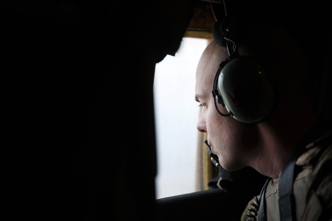 U.S. Air Force Staff Sgt. Justin King scans for threats through the window of a C-130J Super Hercules in route to Camp Bastion, Afghanistan, from Bagram Airfield, Jan. 3, 2016. King is a loadmaster assigned to the 774th Expeditionary Airlift Squadron, deployed from Dyess Air Force Base, Texas. U.S. Air Force photo by Tech. Sgt. Robert Cloys