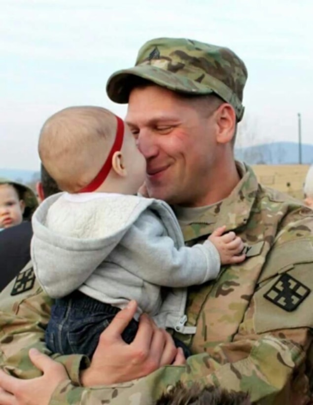 U.S. Army Reserve Sgt. Terry A. Speck Jr., medic, Headquarter and Headquarter Company, 854th Engineer Battalion, and Reading, Pa., native, meets his daughter, Isla, for the first time upon his return from deployment in March 2014. (Courtesy photo)