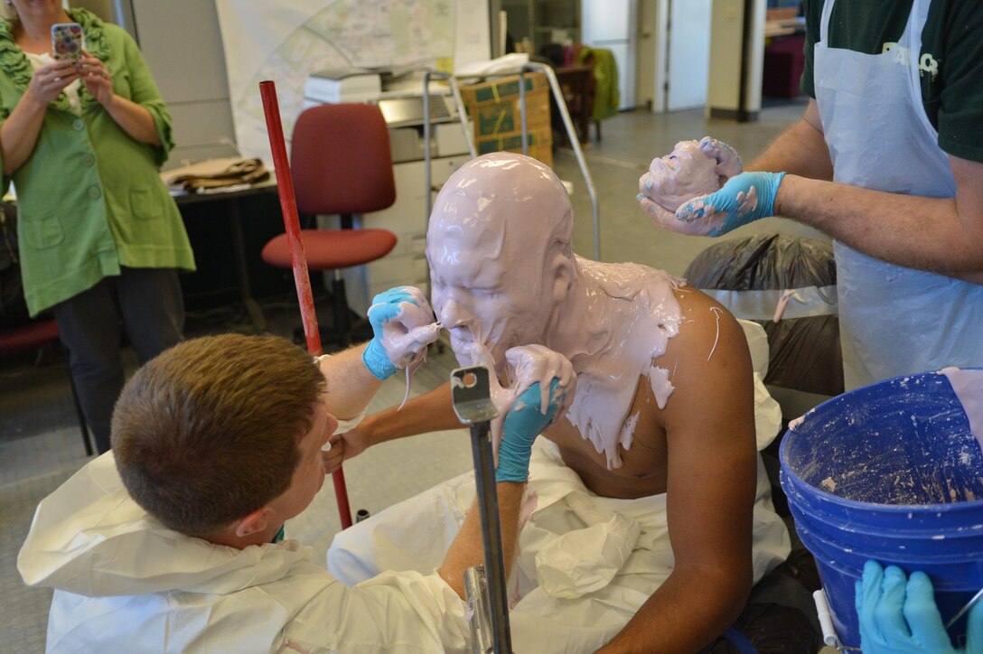 Cpl. Jhon Espinal holds still while employees of Taylor Studios, Inc., an exhibit fabrication studio, apply alginate to his head to create a mold for a cast figure on Nov. 4.