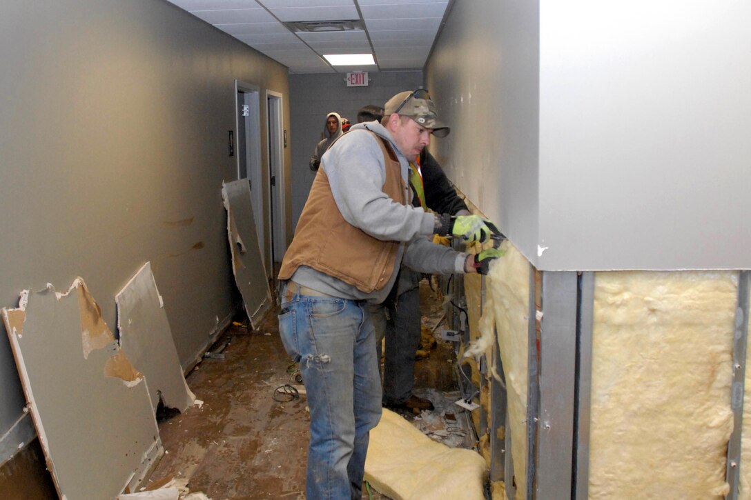 Missouri National Guardsmen and volunteers cut and remove flood-soaked drywall and insulation from a building in Valley Park, Mo., Jan. 2, 2016.  Missouri Air National Guard photo by Maj. Jeffrey M. Bishop