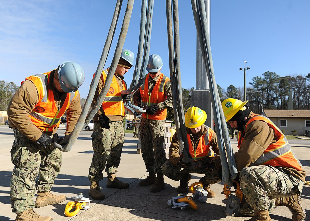 Sailors from Navy Cargo Handling Battalion 1 prepare a shipping container to be lifted by a crane during training at Naval Weapon Station Yorktown in Williamsburg, Va., Jan. 6, 2016. Fifty-four active and reserve component sailors were training in preparation for departure to McMurdo Station, Antarctica, in support of the National Science Foundation. U.S. Navy photo by Petty Officer 2nd Class Benjamin Wooddy