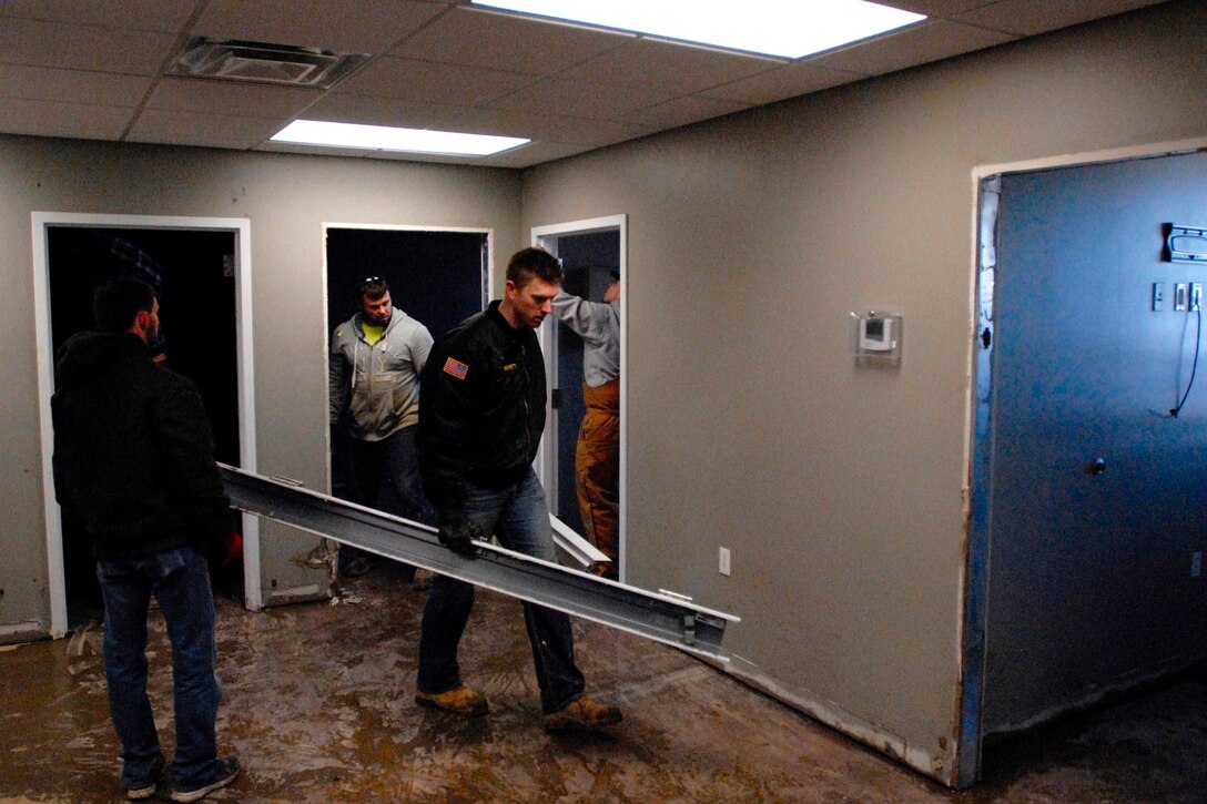 Army Sgt. William Schmitt carries steel door frames to the parking lot so that flood-soaked drywall can be removed from a building in Valley Park, Mo., Jan. 2, 2016. Schmitt is assigned to the Missouri National Guard’s 1138th Military Police Company. Missouri Air National Guard photo by Maj. Jeffrey M. Bishop