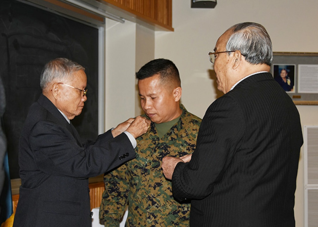 Marine Corps Master Gunnery Sgt. Phu Cao is pinned with his new rank by his father Ty Huu Cao, left, and father-in-law Tu Van, right, during his promotion ceremony Jan. 5 in the McKeever Auditorium on Defense Supply Center Richmond, Virginia.  Cao is currently serving a joint assignment as the senior non-commissioned officer-in-charge for Defense Logistics Agency Aviation’s Marine Aviation Cell. 