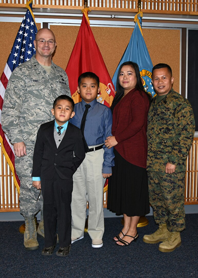 Marine Corps Master Gunnery Sgt. Phu Cao poses with his wife, Tam Thi Tu, two sons, Huy, left, and Trung, right, and Defense Logistics Agency Aviation Commander Air Force Brig. Gen. Allan Day during his promotion ceremony Jan. 5 in the McKeever Auditorium on Defense Supply Center Richmond, Virginia.
