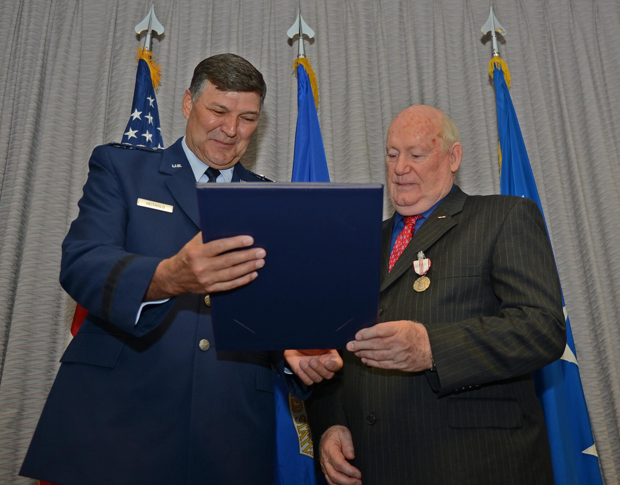 Lt. Gen. Brad Heithold, Air Force Special Operations Command commander, presents a certificate of service to Herb Mason, AFSOC historian, at his retirement ceremony on Hurlburt Field, Fla., Jan. 7, 2016. Mason led the AFSOC history office in completing 25 on-time annual historical reports--a feat unmatched by any other Major Command. (U.S. Air Force photo/Staff Sgt. Melanie Holochwost)