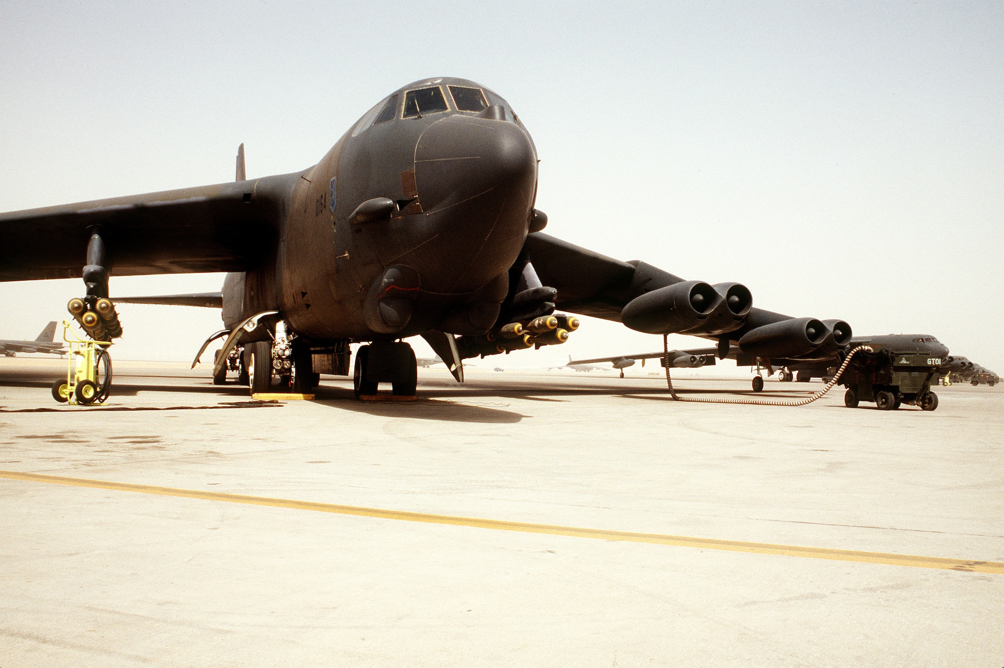 A B-52G Stratofortress aircraft is serviced on the flight line prior to flying a bombing mission against Iraqi forces during Operation Desert Storm. The aircraft is armed with M-117 750-pound bombs.