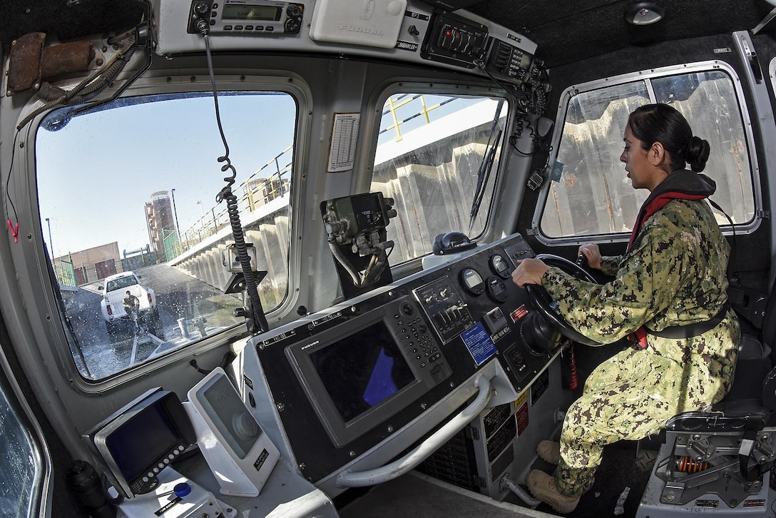 Navy Petty Officer 2nd Class Brianna Caballero maneuvers a harbor patrol boat to load it onto a trailer for maintenance on Naval Support Activity Bahrain, Jan. 6, 2016. Caballero is a machinist's mate. Navy photo by Petty Officer 1st Class Gary Granger Jr.