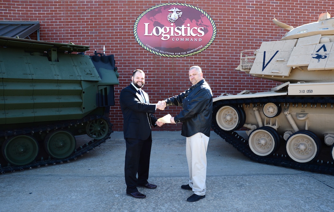 Jody W. Nesbitt (right), project officer, Marine Depot Maintenance Command, officially hands-off three restored combat vehicles to Kater Miller, assistant ordnance curator, National Museum of the Marine Corps, during a ceremony held at the MDMC in Albany, Ga., Jan. 7. The vehicles restored consisted of an M60A1 Main Battle Tank, an Assault Amphibious Vehicle and a Humvee, which are scheduled to be displayed in the NMMC November 2018. Restoration of the equipment began at MDMC in July 2014.