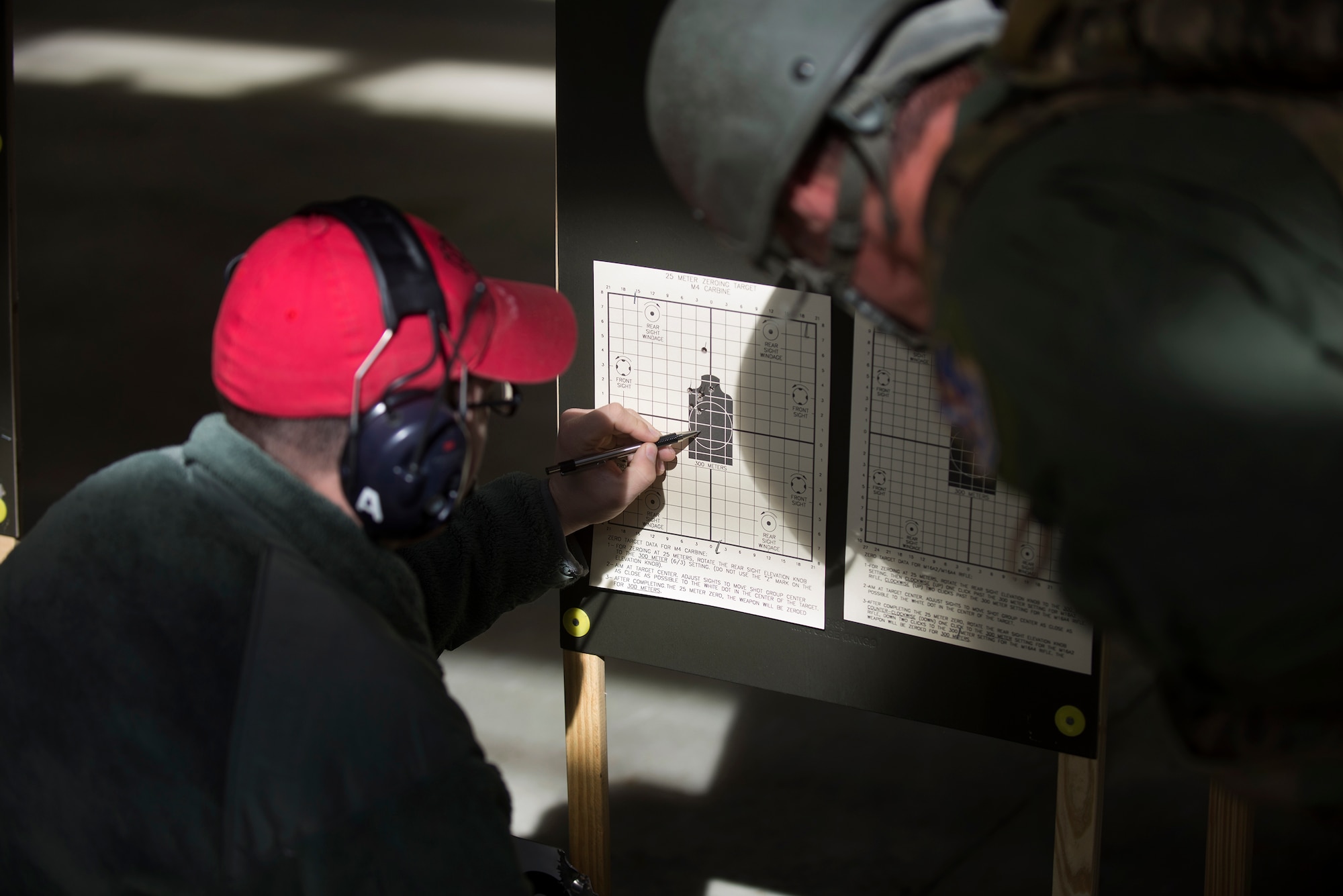 U.S. Air Force Staff Sgt. Robert Thompson, 23d Security Forces Squadron NCO in charge of the armory, left, and Master Sgt. Randy VanHorn, 41st Rescue Squadron flight chief, check a target sheet for accuracy, Jan. 6, 2016, at Moody Air Force Base, Ga. Moody's combat arms training and maintenance instructors are committed to ensuring Airmen are qualified for the mission. (U.S. Air Force photo by Airman Daniel Snider/Released)