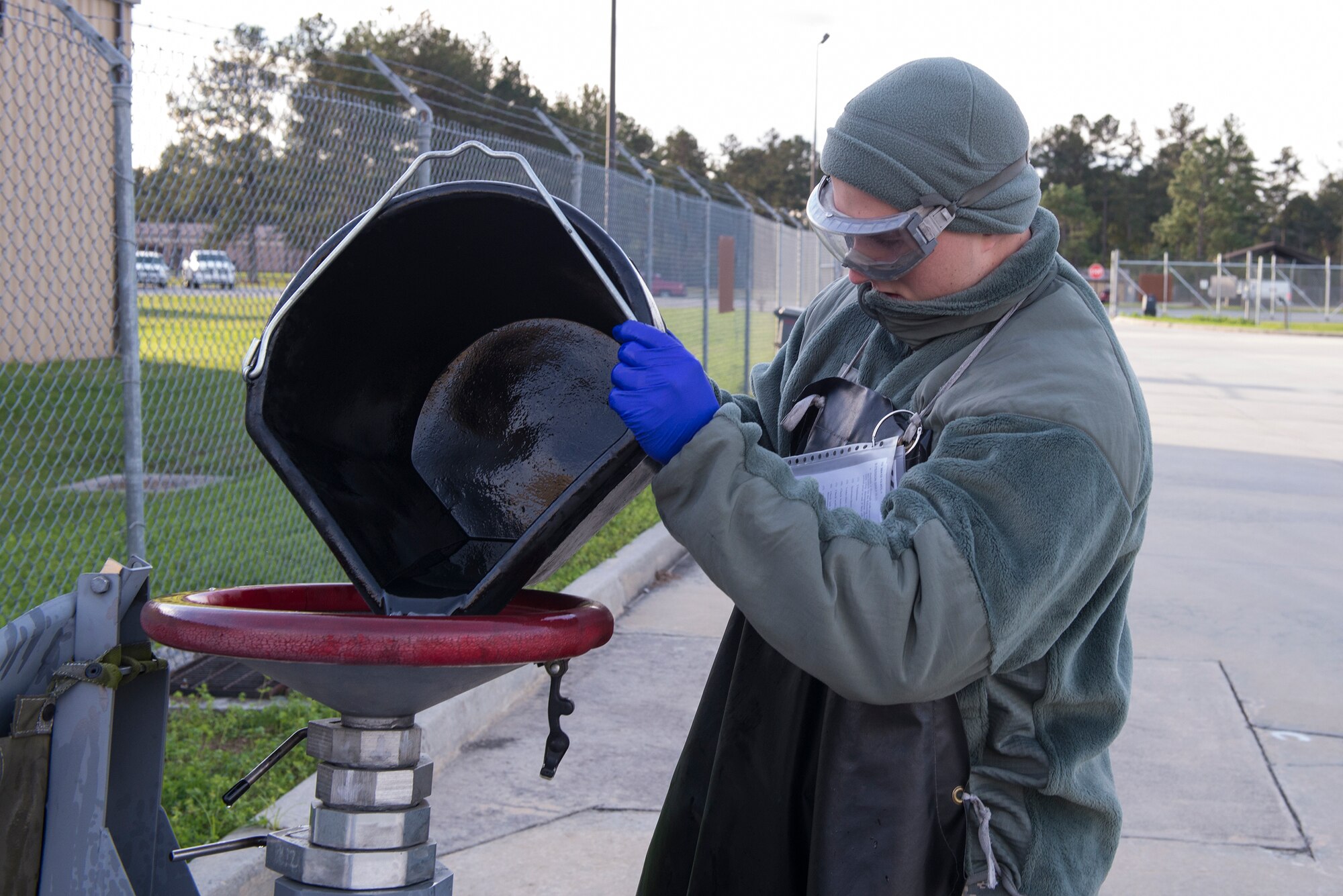U.S. Air Force Airman Brendan Melms, 23d Logistics Readiness Squadron fuels distribution operator, pours waste fuel in a fuel bowser during a checkpoint inspection, Jan. 6, 2016, at Moody Air Force Base, Ga. The waste fuel, containing water and sediments, is poured in the bowser to be defueled while removing contaminants and recirculated into the fuel stream. (U.S. Air Force photo by Airman 1st Class Greg Nash/Released) 
