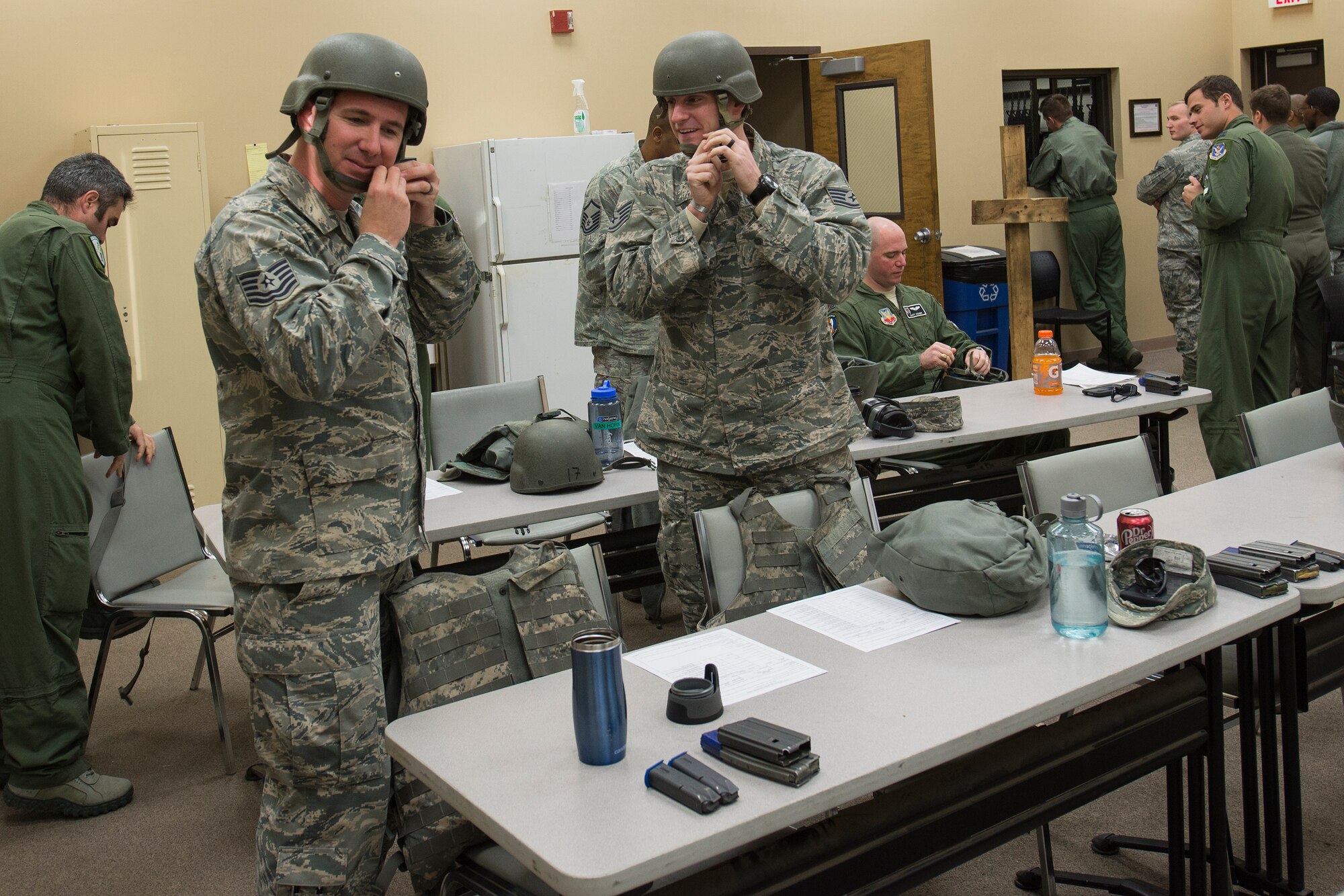 U.S. Air Force Tech. Sgt. Matthew Dennin, left, and Staff Sgt. Edward Rocha, 23d Civil Engineer Squadron water and fuels systems technicians, secure their helmets before heading to the firing range, Jan. 6, 2016, at Moody Air Force Base, Ga. Airmen wear protective helmets, vests and eyewear while qualifying on their weapons. (U.S. Air Force photo by Airman Daniel Snider/Released)