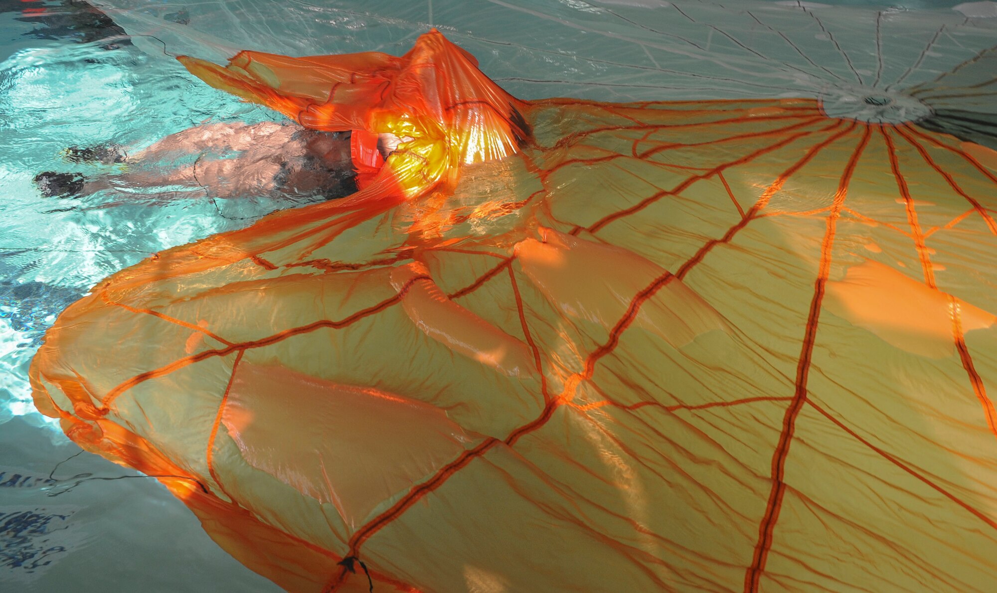 U.S. Air Force Lt. Col. Lance Benson, 43th Electronic Combat Squadron commander, follows a parachute canopy seam during Survival, Evasion, Resistance, Escape training refresher at Davis-Monthan Air Force Base, Ariz., Jan. 6, 2016. By following the seam of the downed parachute canopy and avoiding swimming with their legs, entanglement is almost eliminated in the event of a water landing. (U.S. Air Force photo by Airmen 1st Class Ashley N. Steffen/Released)  