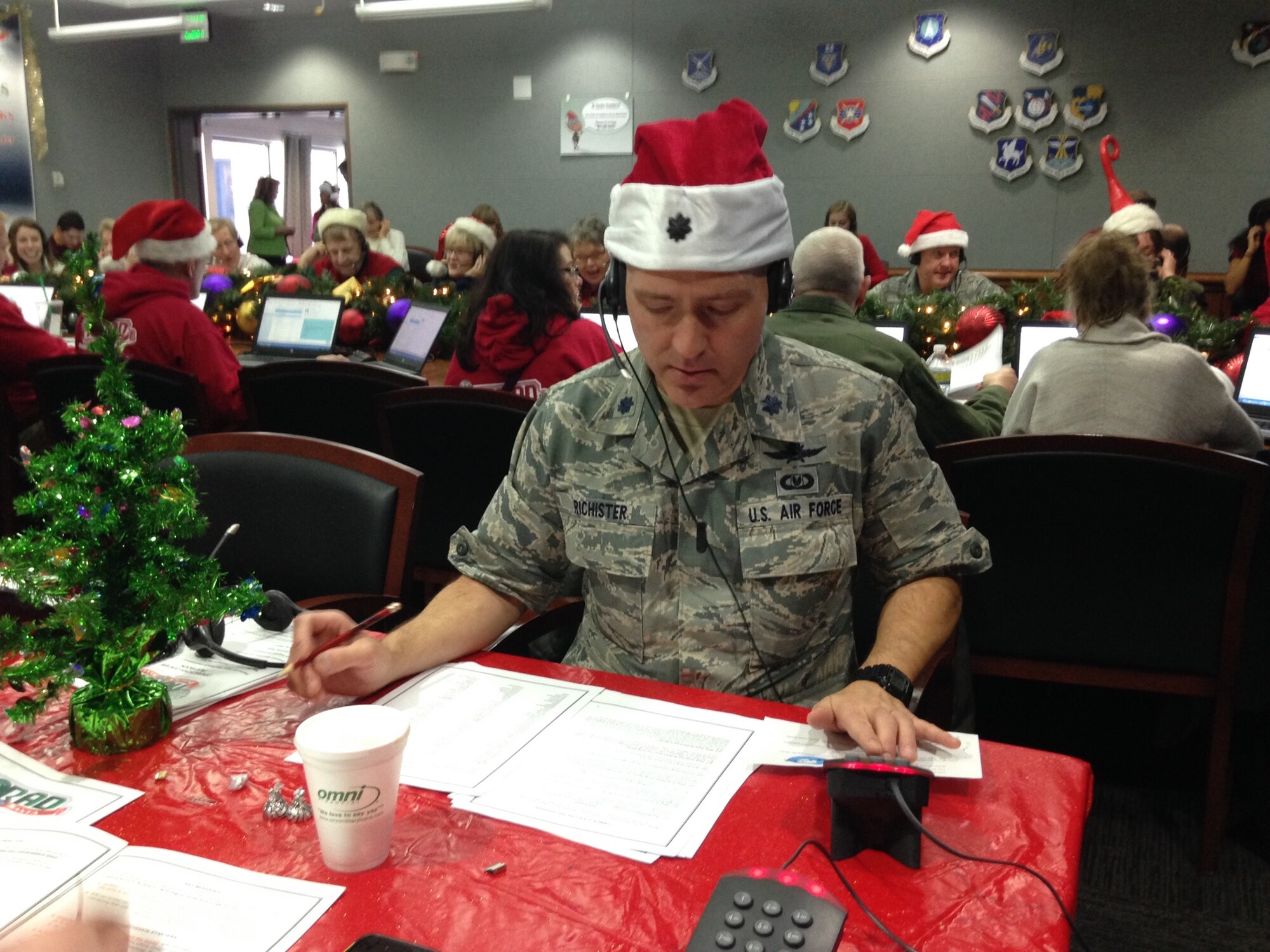U.S. Air Force Reserve Lt. Col. Stan Richister, 960th Network Operations Squadron director of operations, takes a call during the NORAD Tracks Santa program.  Richister and more than 1,500 other volunteers from Peterson Air Force Base, Colo., and the surrounding communities fielded nearly 141,000 calls from around the world on Dec. 24, 2015 from 6 a.m. EST until 3 a.m. EST on Dec. 25, 2015, detailing the whereabouts of Santa for adults and children alike. The NORAD Tracks Santa program celebrated its 60th year of operations, bringing holiday cheers to callers, in what originally started as a misprinted telephone number in a local department store newspaper advertisement. (U.S. Air Force Photo/Mike Pierson)