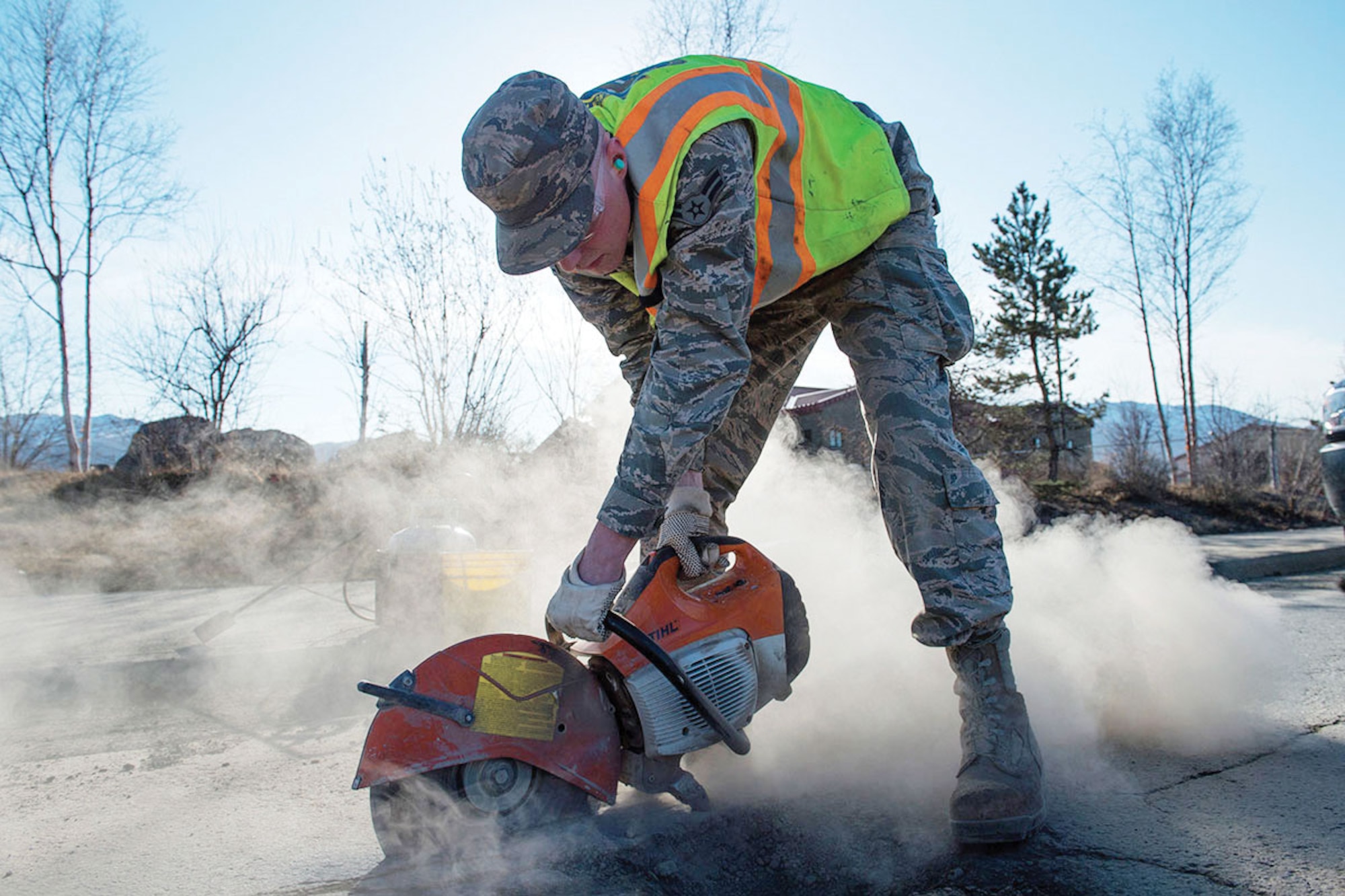 Airman 1st Class Jeremy Clapham, assigned to the 773rd Civil Engineer Squadron, uses a saw to cut into the asphalt around a pothole while performing road improvements on Joint Base Elmendorf-Richardson last April. The 773rd CES Airmen repaired potholes around base to maintain safe road conditions. (U.S. Air Force photo/Alejandro Pena)