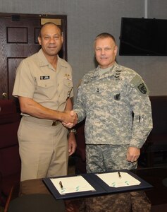 U.S. Army Maj. Gen. Allen W. Batschelet (right), U.S. Strategic Command (USSTRATCOM) chief of staff, and U.S. Navy Rear Adm. Vincent L. Griffith, Defense Logistics Agency (DLA) director of logistics operations, pose for a photo after signing a memorandum of agreement (MOA) on behalf of their respective organizations at USSTRATCOM Headquarters, Offutt Air Force Base, Neb., Jan. 7, 2016. The MOA defines the level of DLA logistics support to U.S. Strategic Command operations and outlines continuing collaboration to improve sustainment for the nation's nuclear enterprise. After signing the document, Griffith toured the headquarters facilities and held discussions with senior leaders at USSTRATCOM. One of nine DoD unified combatant commands, USSTRATCOM has global strategic missions, assigned through the Unified Command Plan, which include strategic deterrence; space operations; cyberspace operations; joint electronic warfare; global strike; missile defense; intelligence, surveillance and reconnaissance; combating weapons of mass destruction; and analysis and targeting. (USSTRATCOM photo by Steve Cunningham)