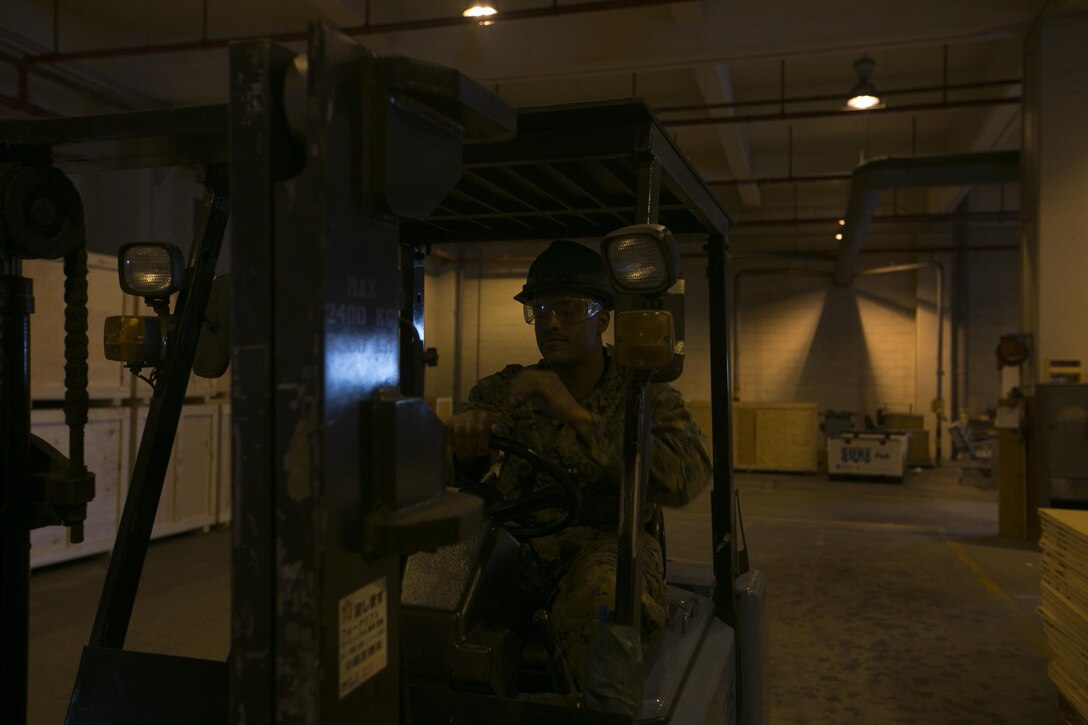 A freight specialist operates a fork lift Dec 18. in the distribution management office aboard Camp Kinser, Okinawa, Japan. Freight is one of three sections within the DMO along with personal property shipping office and passenger transportation office. These three sections are responsible for transporting everything from a Marine’s couch back to the United States to ammunition for riflemen deployed all across the world.