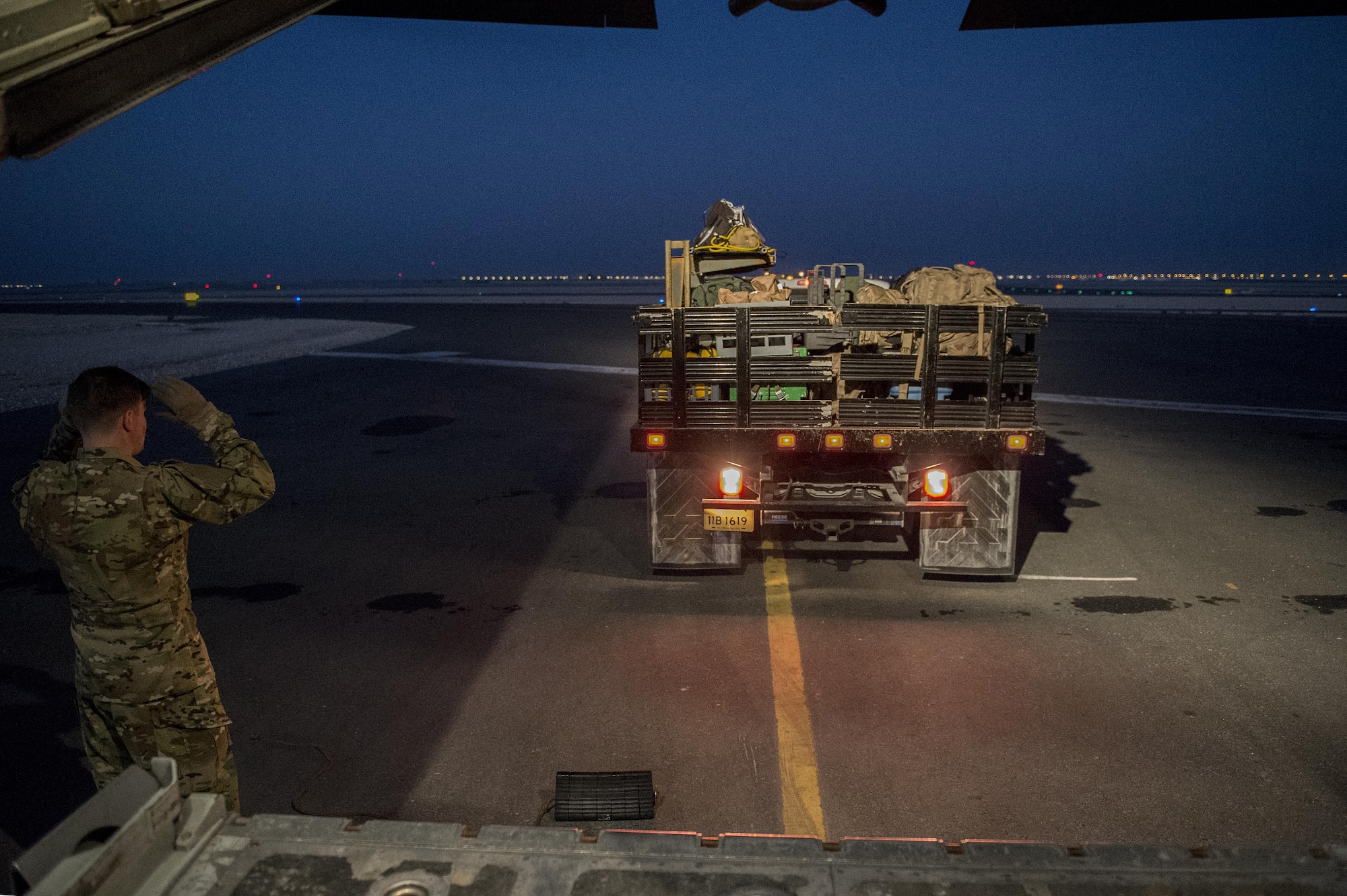 U.S. Air Force Tech. Sgt. Zeb Petterborg, 379th Expeditionary Aeromedical Evacuation Squadron medical technician, marshals a truck of medical equipment to the back of a C-130H Hercules at Al Udeid Air Base, Qatar in support of Operation Inherent Resolve, Jan. 6, 2016. OIR is the coalition intervention against the Islamic State of Iraq and the Levant. (U.S. Air Force photo by Tech. Sgt. Nathan Lipscomb)
