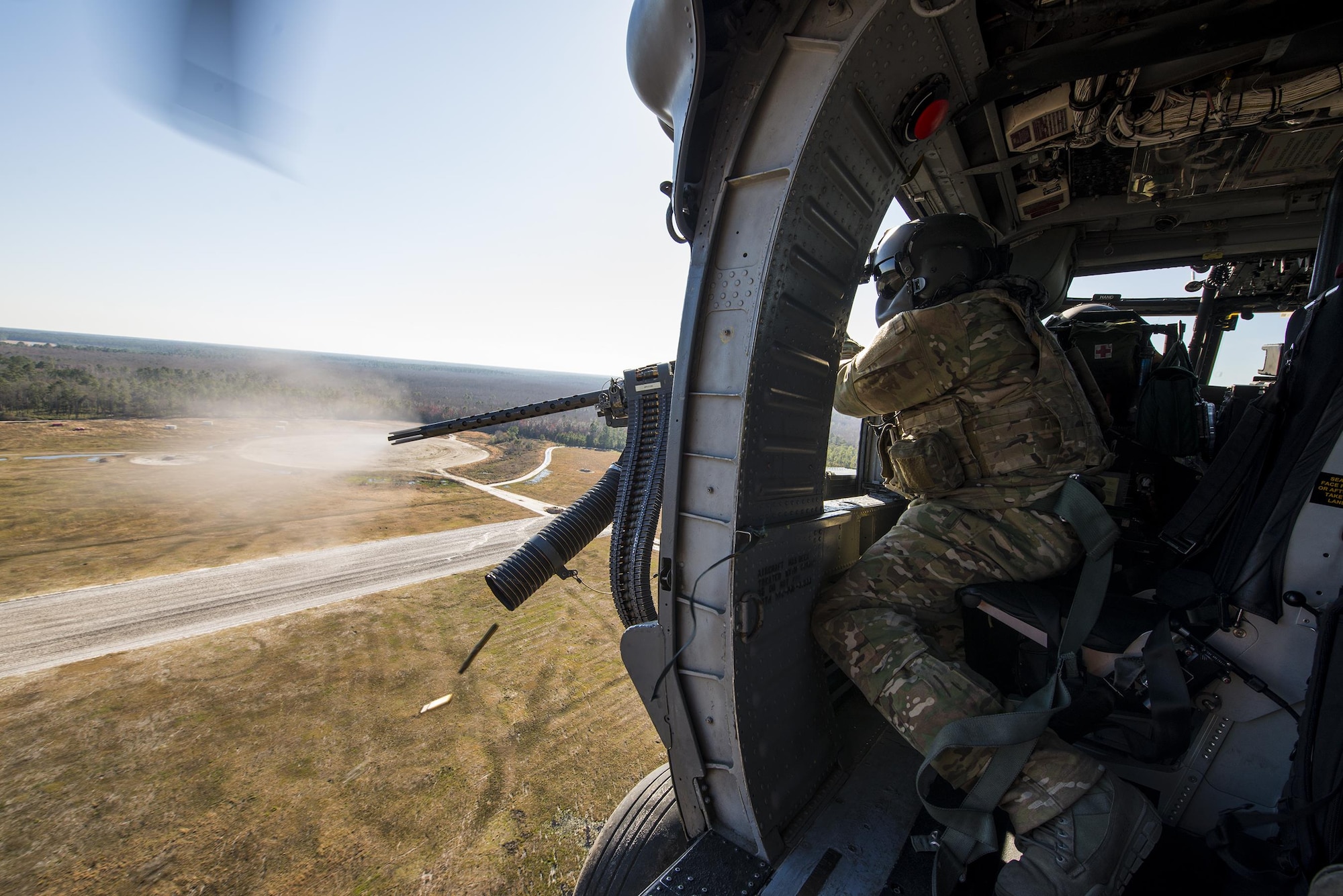 Tech. Sgt. Uwemediimo Essien fires a .50-caliber machine gun at simulated enemy targets while flying over Grand Bay Bombing and Gunnery Range Feb. 19, 2015, at Moody Air Force Base, Ga. The side-mounted, .50-caliber machine gun is the HH-60G Pave Hawk’s primary form of defense. Essien is a 41st Rescue Squadron aerial gunner. (U.S. Air Force photo/Senior Airman Ryan Callaghan)