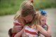 Capt. Ross Farling, a C-130 Hercules pilot from the 123rd Airlift Wing, hugs his daughters during a homecoming ceremony in Louisville, Ky., July 4, 2015. Farling was among 39 guardsmen who returned from a deployment to the Persian Gulf region, where they supported Operation Freedom's Sentinel. (U.S. Air National Guard photo/Maj. Dale Greer)