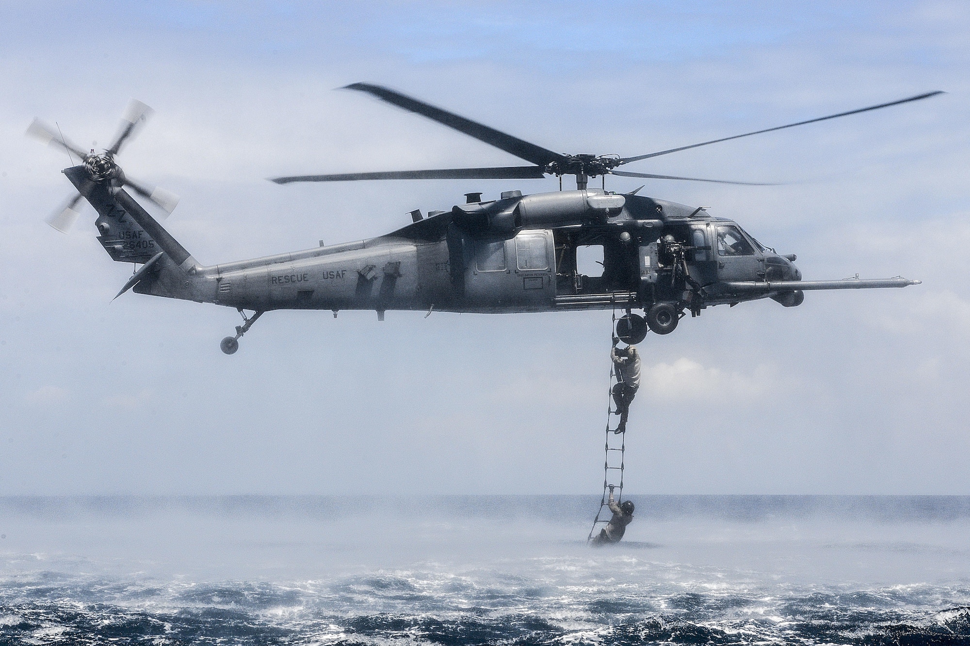 An HH-60G Pave Hawk from the 33rd Rescue Squadron at Kadena Air Base, Japan, performs a rope-ladder recovery with Airmen from the 320th Special Tactics Squadron during an amphibious operations exercise Sept. 22, 2015, off the west coast of Okinawa, Japan. Special tactics Airmen are organized, trained and equipped to conduct high-risk combat operations. (U.S. Air Force photo/Senior Airman John Linzmeier)