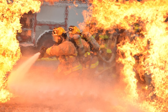 Air Force firefighters rush into extreme temperatures to extinguish a fire during training at the 165th Airlift Wing in Garden City, Ga., Oct. 3, 2015. Firefighters from the 165th AW train to meet local and global protection needs and provide timely fire prevention education and protection to the wing, the Air Dominance Center and the airport tenants. (U.S. Air National Guard photo/Staff Sgt. Noel Velez)