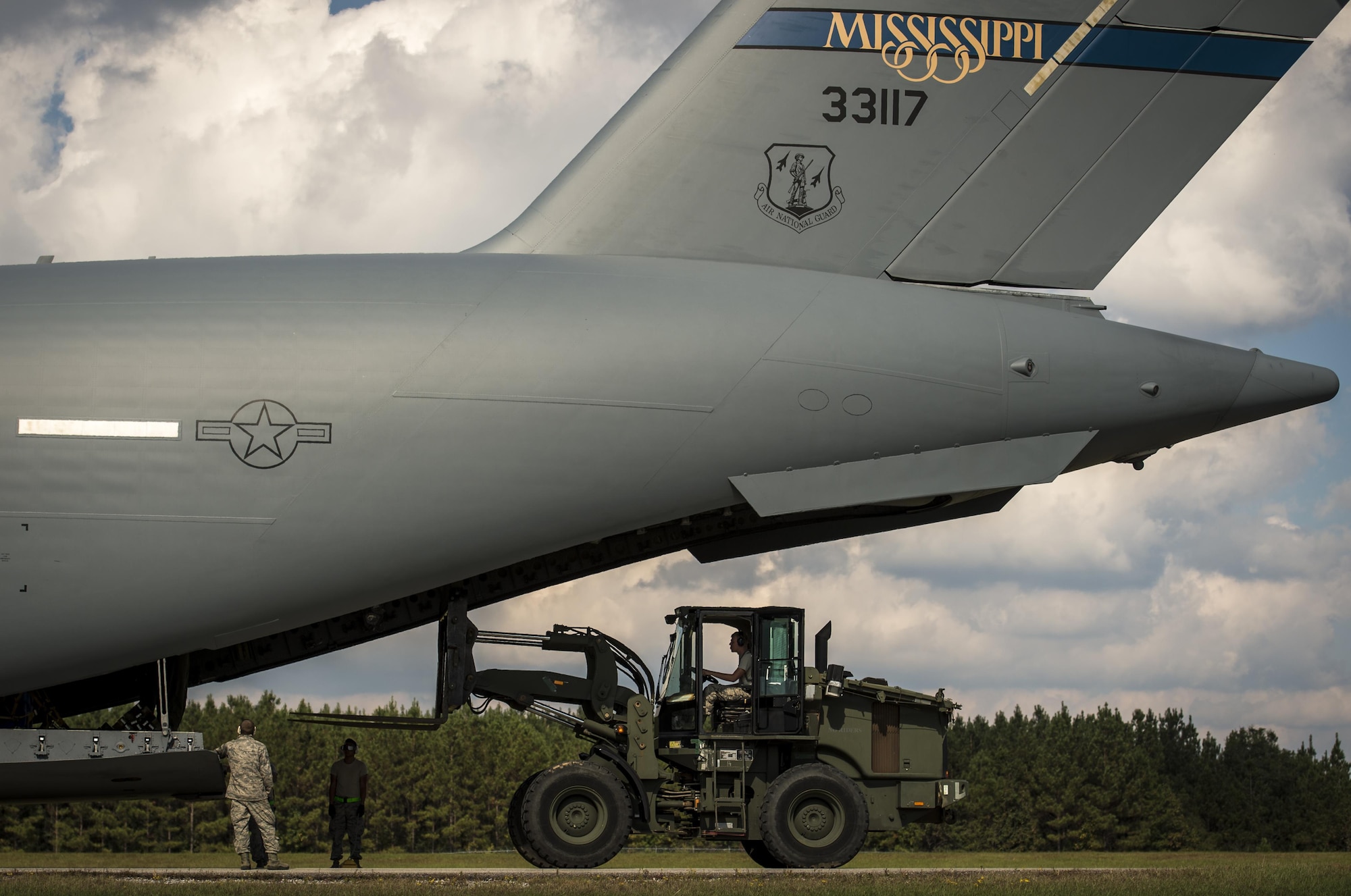 Airmen from the 321st Contingency Response Squadron and Soldiers from the 689th Rapid Port Opening Element offload cargo from a Mississippi Air National Guard C-17 Globemaster III on the flightline at Camp Shelby Joint Forces Training Center, Miss., during exercise Turbo Distribution Oct. 29, 2015. The U.S. Transportation Command exercise tested the Joint Task Force Port-Opening's ability to deliver and distribute cargo during humanitarian relief operations. The 321st CRS is from Joint Base McGuire-Dix-Lakehurst, N.J., and the 689th RPOE is from Joint Base Langley-Eustis, Va. (U.S. Air Force photo/Staff Sgt. Marianique Santos)