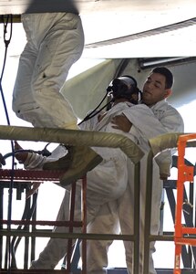 Senior Airman Eric Garcia, 433rd Maintenance Squadron aircraft fuel systems technician, removes a manikin from the wing of a C-5A Galaxy aircraft during a fuell extraction exercise Dec. 17, 2015, at Joint Base San Antonio-Lackland, Texas. The annual exercise is graded for extraction protocol, execution time, and safety. This year the Airmen completed the exercise in record time, 3 minutes and 15 seconds. (U.S. Air Force photo by Benjamin Faske/released)