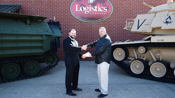 Jody W. Nesbitt (right), project officer, Marine Depot Maintenance Command, officially hands-off three restored combat vehicles to Kater Miller, assistant ordnance curator, National Museum of the Marine Corps, during a ceremony held at the MDMC in Albany, Ga., Jan. 7. The vehicles restored consisted of an M60A1 Main Battle Tank, an Assault Amphibious Vehicle and a Humvee, which are scheduled to be displayed in the NMMC November 2018. Restoration of the equipment began at MDMC in July 2014.