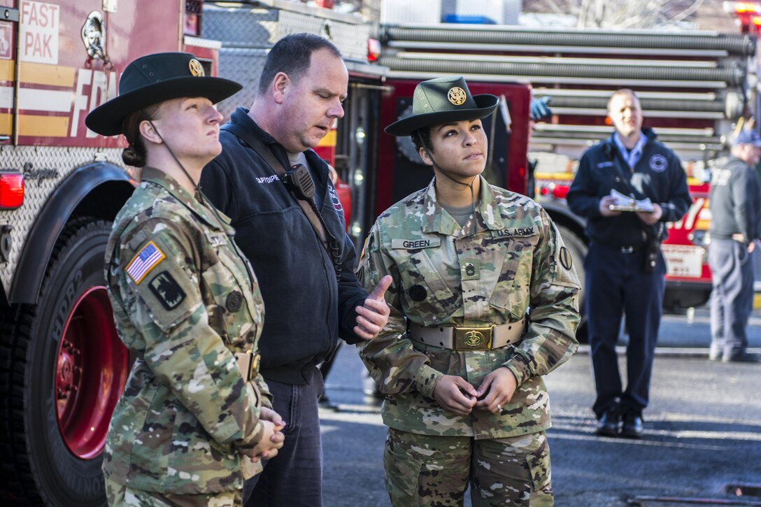 Sgt. 1st Class Tanya Green (right) and Staff Sgt. Autumn Beaty (left), both drill sergeant leaders with the United States Army Drill Sgt. Academy located at Fort Jackson, S.C., observe as New York City firefighters work to extinguish flames from a burning building during a live-fire exercise at the New York City Fire Academy on Russell Island in New York City, Jan. 6, 2016. New York City Fire Academy on Russell Island in New York City, Jan. 6, 2016. The two were at the Fire Academy Jan. 4-8, to observe training as part of a collaboration between the Fire Department of New York and the Center for Initial Military Training providing lessons learned and offering alternate training methods for new recruits. (U.S. Army photo by Sgt. 1st Class Brian Hamilton)