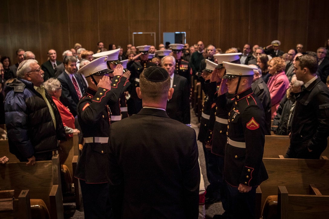 Marines with Recruiting Substation Brockton, Massachusetts, salute the casket of Sam Bernstein at Temple Beth AM, Dec. 30. Bernstein was a former Marine during World War II where he participated in the battle of Iwo Jima, taking some sand home with him. Although leaving the service in 1946, he remained proud of his service and for being a Marine. The Marines of RSS Brockton volunteered to assist with the funeral.