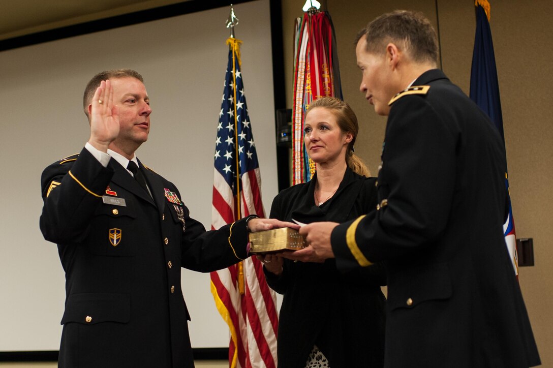 Command Sgt. Maj. James P. Wills takes the oath of office as his wife, Lisa, holds a family Bible during a change of responsibility ceremony at the U.S. Army Forces Command and U.S. Army Reserve Command headquarters, Jan. 8, 2016, at Fort Bragg, N.C. Wills takes over the U.S. Army Reserve's top enlisted position from Command Sgt. Maj. Luther Thomas Jr., who will be the senior enlisted adviser to the assistant secretary of defense for Manpower and Reserve Affairs. (U.S. Army photo by Timothy L. Hale/Released)