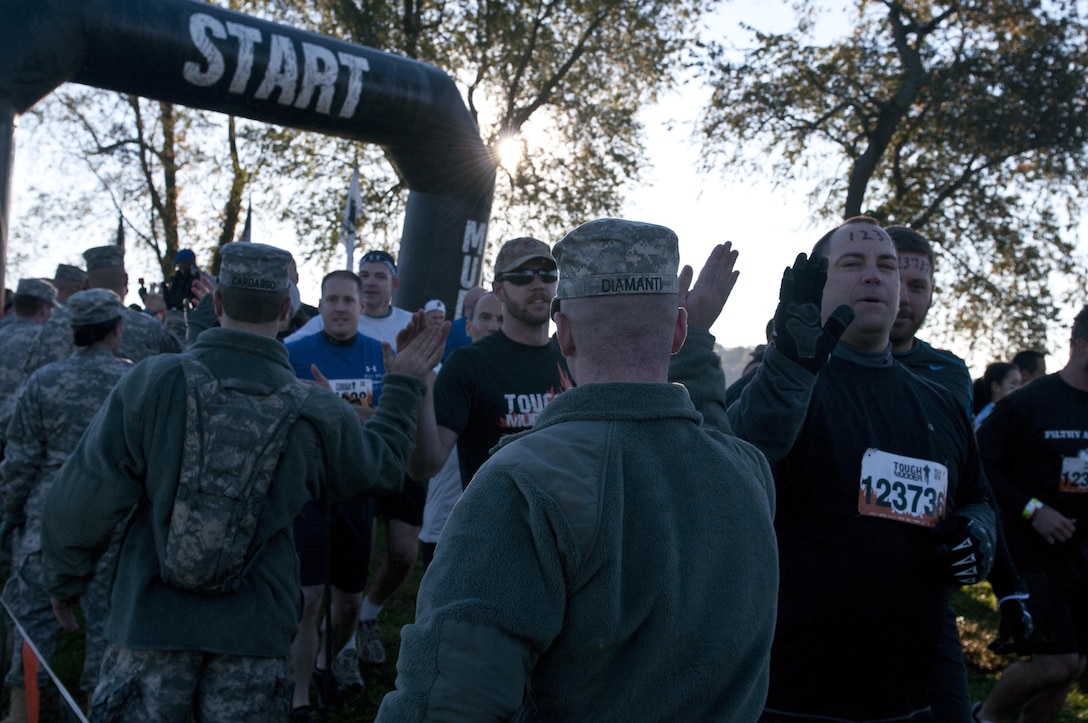 U.S. Army Reserve Pvt. Anthony Diamanti, 369th Engineer Detachment (Firefighting), a military and civilian firefighter from Berlington, N.J., offers encouragement to Tough Mudders during Tough Mudder Philly in Coatesville, Pa., Oct. 17. (U.S. Army photo by Staff Sgt. Debralee Best)