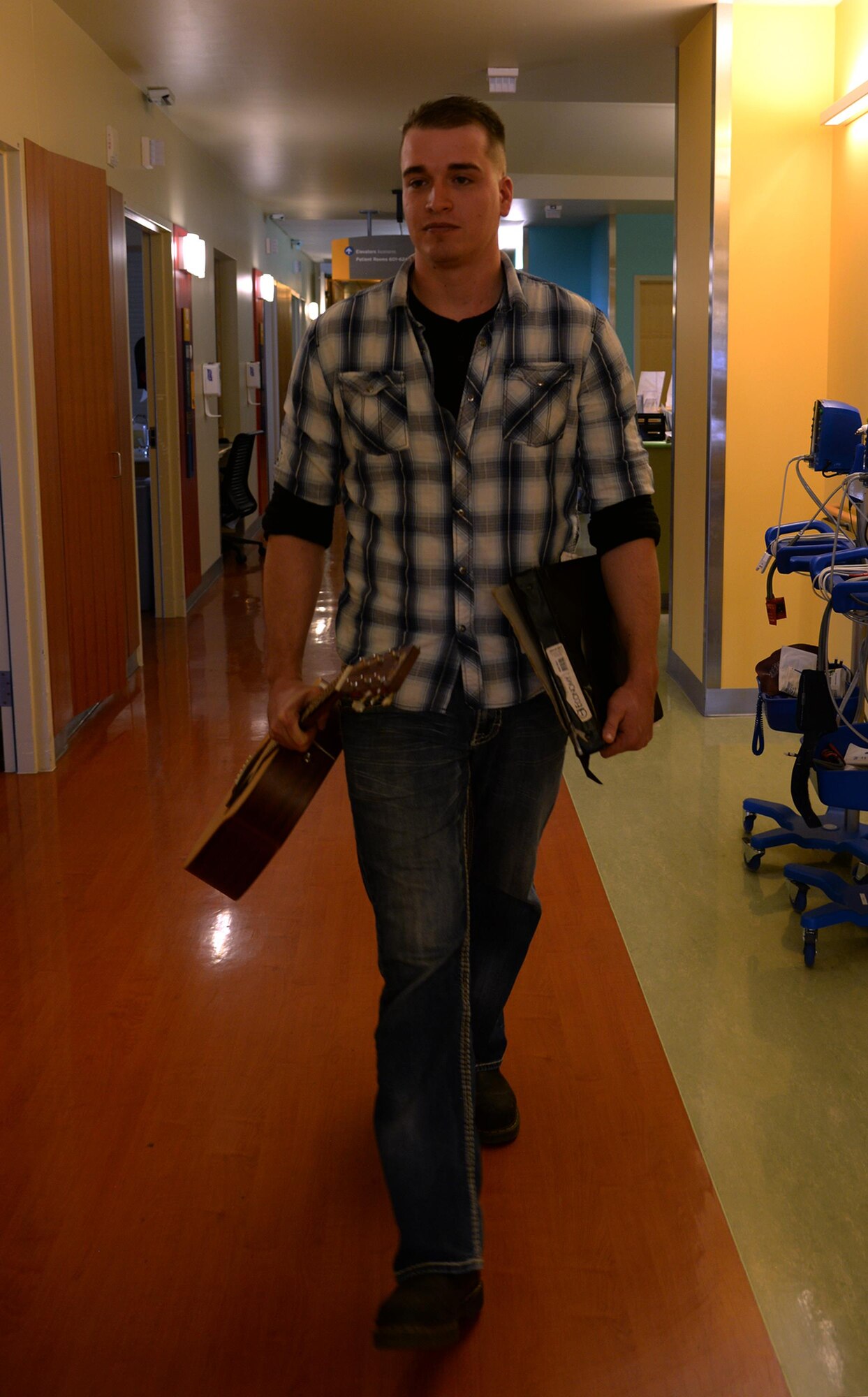 Airman 1st Class Dylan Westmoreland, 790th Quick Response Force, walks through the halls of the Children's Hospital Colorado in Aurora, Colorado, Jan. 6, 2016. Westmoreland volunteered his time to play music for patients of the hospital, visiting two floors of rooms. (U.S. Air Force photo by Airman 1st Class Malcolm Mayfield)