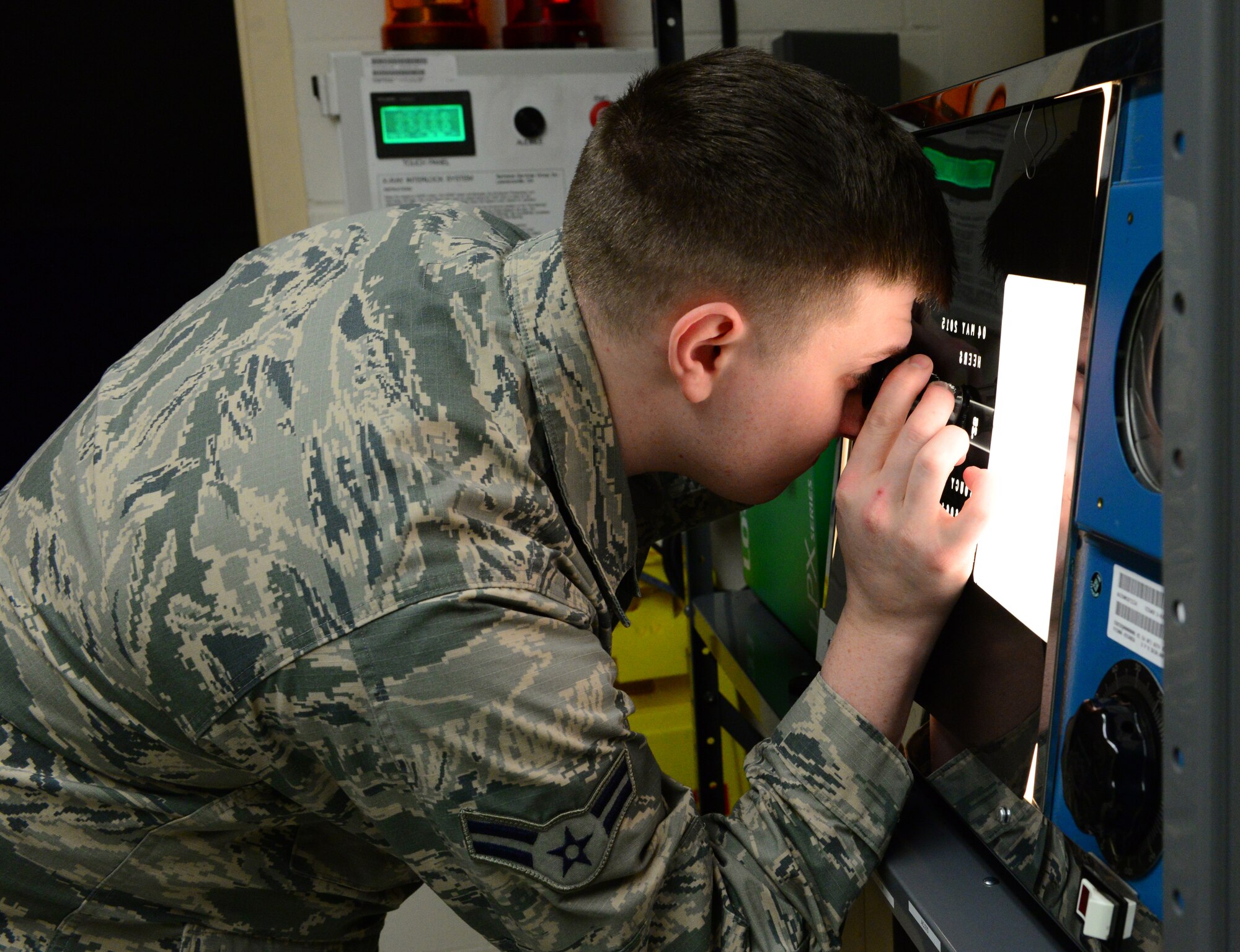 U.S. Air Force Airman 1st Class Christopher Reynolds Jr., a 354th Maintenance Squadron nondestructive inspection journeyman, uses a magnifying glass to enhance the x-ray of a part Jan. 6, 2016, at Eielson Air Force Base, Alaska. This is done to better see welds on certain parts to ensure the weld is complete. (U.S. Air Force photo by Airman 1st Class Cassandra Whitman/Released) 