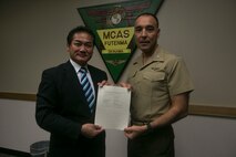Col. Peter Lee and Ginowan Mayor Atsuchi Sakima pose for a photog Dec. 22 on Marine Corps Air Station Futenma, Okinawa, Japan. Lee and Sakima signed an extension on the Ginowan emergency vehicle and personnel access agreement. In order to save time and lives, the agreement gives Okinawan emergency vehicles and personnel base access in case of an emergency. According to Lee, commanding officer of MCAS Futenma, the agreement is just a small part of the overall partnership between the Ginowan community and the Marine Corps.