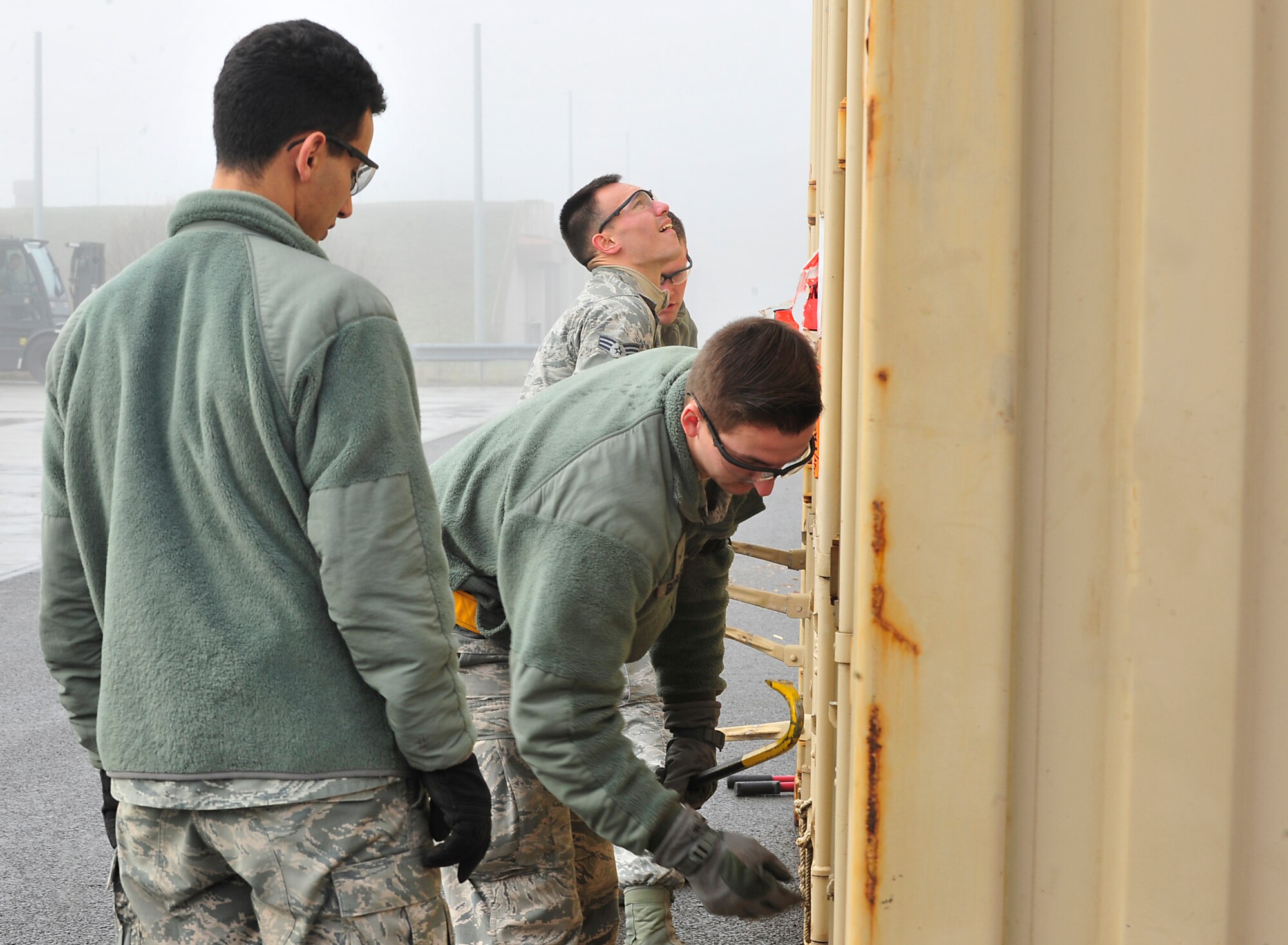 86th Munitions Squadron Airmen open a container carrying armaments Dec. 8, 2015, at Ramstein Air Base, Germany. The Airmen sort, inspect, ship and maintain accountability for munitions staying at Ramstein as well as ones that will be shipped to allied nations. (U.S. Air Force photo/Airman 1st Class Larissa Greatwood)