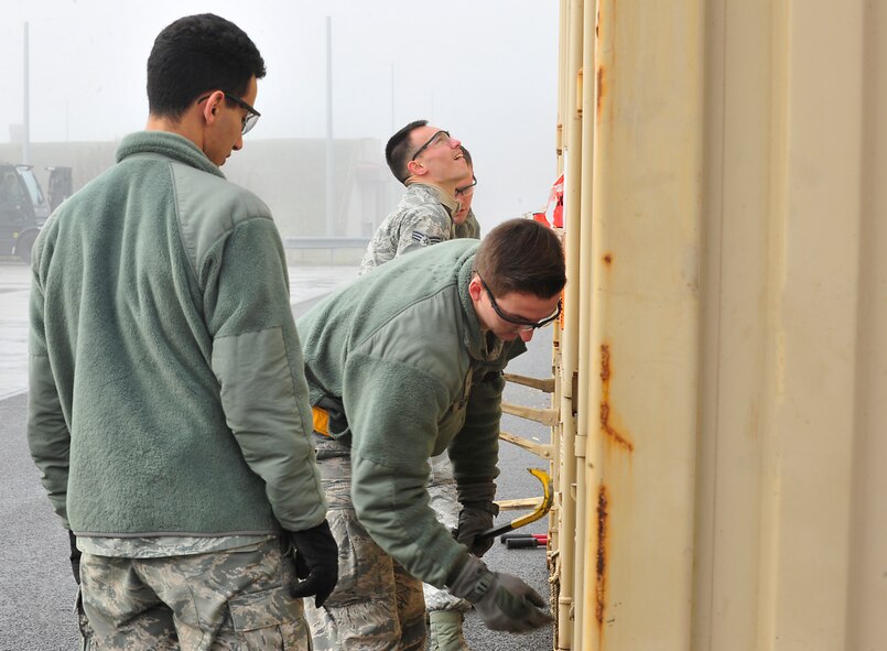 86th Munitions Squadron Airmen open a container carrying armaments Dec. 8, 2015, at Ramstein Air Base, Germany. The Airmen sort, inspect, ship and maintain accountability for munitions staying at Ramstein as well as ones that will be shipped to allied nations. (U.S. Air Force photo/Airman 1st Class Larissa Greatwood)